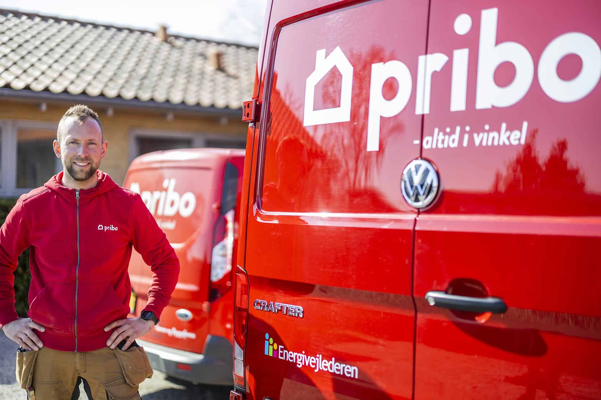 Mand ved to røde varevogne